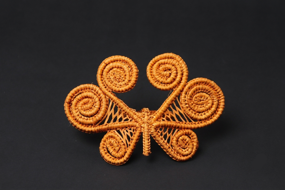 Decorative butterfly-shaped object with intricate patterns on a black background