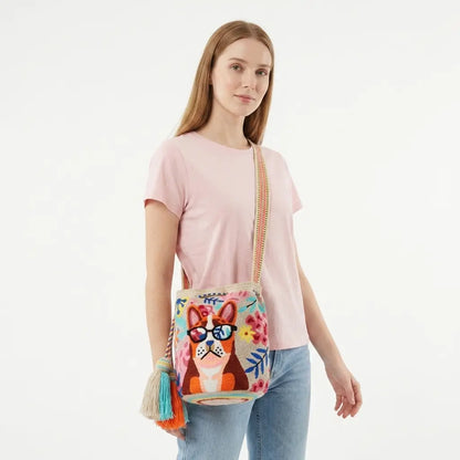 Woman holding a colorful handbag with a dog design on a white background