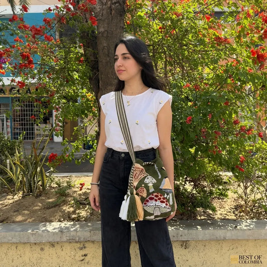 Woman holding a colorful bag in a garden setting